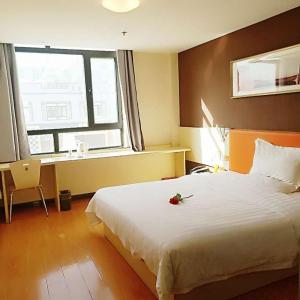 金昌7天酒店·金昌文化街店的卧室设有一张白色大床和一扇窗户。