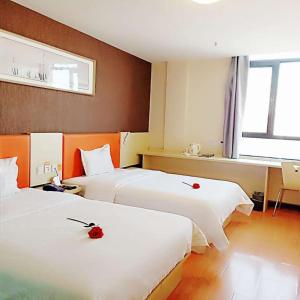 金昌7天酒店·金昌文化街店的酒店客房设有两张红色玫瑰床。