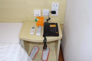 巴中7天酒店·巴中国际商贸城店的一张桌子上的电话,床边