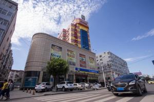 张家口7天酒店·张家口明德北路店的一条繁忙的城市街道,汽车停在大楼前