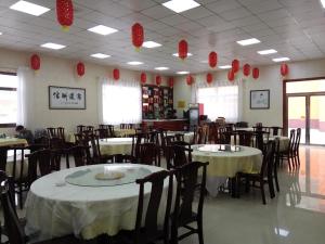 榆林7天酒店·榆林广济大厦店的餐厅设有桌椅和红色纸灯笼