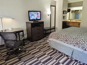 南海文南海文戴斯酒店的酒店客房配有一张床、一张书桌和一台电视。