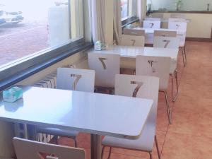 Huadian7天酒店·德州齐河客运中心店的教室里一排白色的桌椅