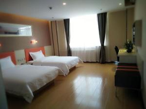 石嘴山7天优品·石嘴山大武口店的酒店客房设有两张床和窗户。