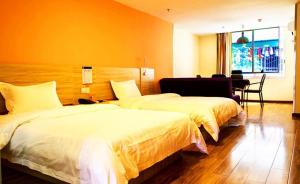 Shuangjiang7天酒店·重庆云阳客运中心站店的酒店客房配有两张床和一张书桌