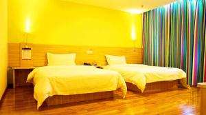 Shuangjiang7天酒店·重庆云阳客运中心站店的一间卧室设有两张床和黄色的墙壁