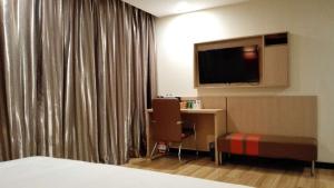 唐山7天优品·唐山新华西道理工大学店的酒店客房配有一张床、一张书桌和一台电视。