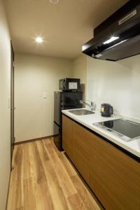 伊万里市Hotel Imari Aioibashi Bettei的厨房配有水槽和冰箱