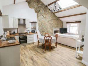 格拉辛顿Rose Cottage的厨房以及带桌椅的起居室。