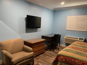 加迪纳市Redondo Beach Motel - LAX的一间卧室配有一张床、一把椅子和电视。