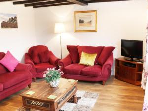ShelveNant-Isa的客厅配有2张红色沙发和电视