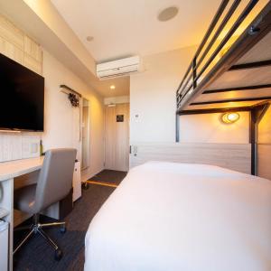 长泉Super Hotel Nagaizumi Numazu Inter的酒店客房设有一张大床和一张书桌。