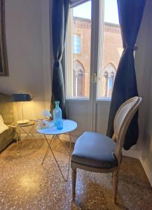 博洛尼亚Residenza del Duse的客房设有桌子、椅子和窗户。
