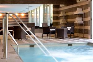 圣地亚哥圣地亚哥假日酒店 - 机场航站楼的一座配有桌椅的酒店游泳池