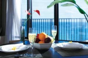 宜野湾市月球海洋宜野湾公寓酒店的一张桌子,上面放着一碗水果和一杯香槟