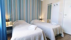 克拉科夫普瑞米安旅馆的一间设有两张带白色床单的床的房间