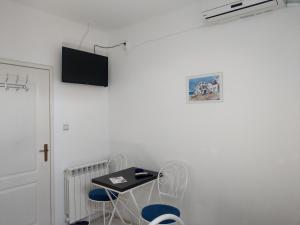阿帕丁Apartment Harmonija apatin的一间房间,墙上有椅子和电视