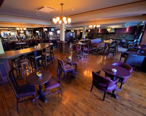 恩尼斯特利斯西县会议和休闲中心酒店的一间带桌椅的餐厅和一间酒吧