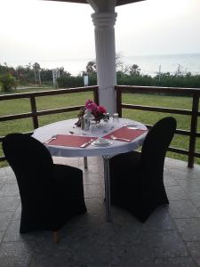 Brufut海洋别墅高地酒店的一张桌子、黑色的椅子和一张桌子,上面有鲜花
