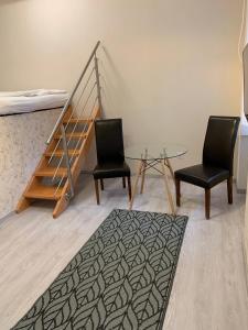米什科尔茨W19 Apartments的一间设有两把椅子、一张桌子和一张床的房间