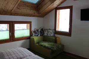 采尔马特加迪木屋酒店的一间卧室配有绿色椅子和一张床