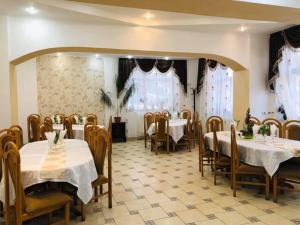 瓦特拉多尔内Pensiunea Valurile Bistritei的餐厅设有白色的桌椅和窗户。