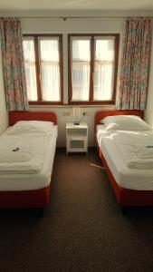 罗滕堡金色玫瑰精品酒店的带2扇窗户的客房内的2张床
