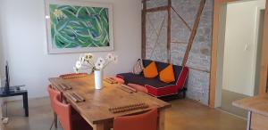 卢塞恩Easy-Living Apartments Lindenstrasse 21的用餐室配有桌子和带橙色枕头的沙发