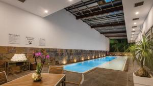 普埃布拉普埃布拉智选假日酒店的一座带桌子和鲜花的建筑中的游泳池