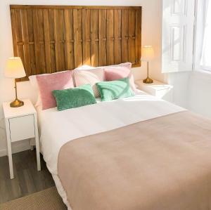 埃武拉Casa dos Castelos的一间卧室配有一张带色彩缤纷枕头的大床