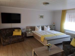 旺格兰Pension Arndt UG的酒店客房设有一张大床和一张沙发。