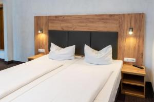 奥格斯堡费舍尔特尔酒店的一间卧室配有两张带白色枕头的床