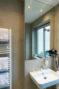 奥格斯堡费舍尔特尔酒店的一间带水槽和镜子的浴室