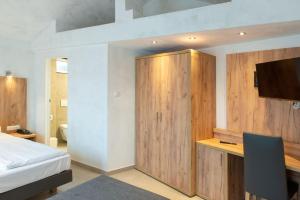 奥格斯堡费舍尔特尔酒店的一间卧室配有一张床和一个木制橱柜