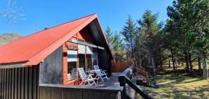 阿克拉内斯Bard Cottage的一间拥有橙色屋顶和甲板的小屋