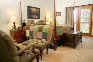 赛维尔维尔Berry Springs Lodge的一间卧室配有一张床、一把椅子和一张沙发