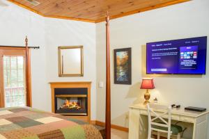 赛维尔维尔Berry Springs Lodge的一间卧室配有一张床、一张桌子和一个壁炉