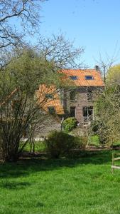HuppayeLa Miellerie的绿色田野上一座带橙色屋顶的房子