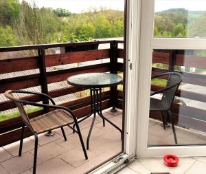 捷克克鲁姆洛夫亚当公寓式酒店的美景阳台配有一张桌子和两把椅子