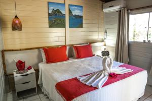 费尔南多 - 迪诺罗尼亚Pousada Sueste的一间卧室配有红色和白色床单
