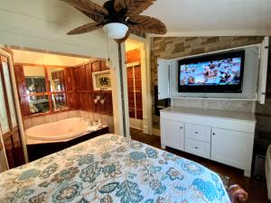 温泉城The Gables Inn的一间卧室配有一张床、一台电视和一个浴缸