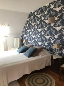 Saint-Lambert-la-Potherie格兰德美因哥特住宿加早餐旅馆的一间卧室配有一张蓝色和白色壁纸的床