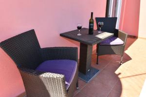 沃迪切Apartments Villa Miranda的一张桌子,上面放着一瓶葡萄酒和两杯酒杯