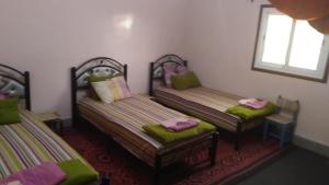瓦尔扎扎特Auberge De la Jeunesse的配有绿色靠垫的客房内的两张床