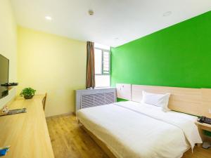 西宁7天酒店·西宁昆仑路十字店的一间卧室设有一张大床和绿色的墙壁