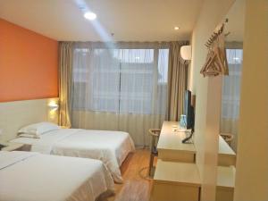 乐山7天酒店·峨眉山中心店的酒店客房设有两张床和电视。