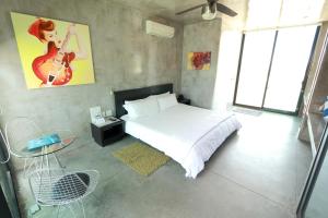 Boca de la Vinorama维达首尔酒店的卧室配有一张床、一张桌子和墙上的吉他