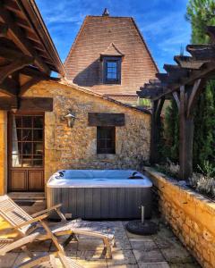 BaneuilLa Closerie de Baneuil的房屋后院的热水浴池