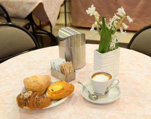 佛罗伦萨卡勒吉酒店的一张桌子,上面放着一杯咖啡和一盘糕点