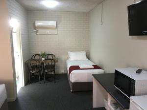 达博阿特拉斯汽车旅馆的小房间设有一张床、一张桌子和椅子
